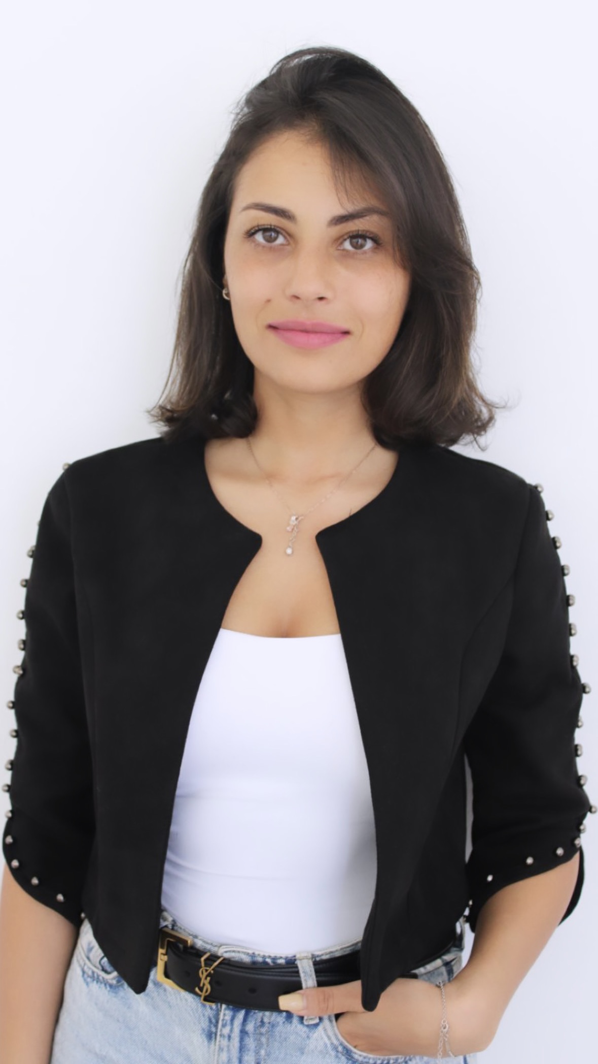 Portrait of Khadija El Abi, Head of Partnerships at Wicked Games, wearing a black jacket and white top, standing against a clean white background.